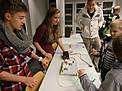 Physik zum "Anfassen": zwei Schüler bringen eine Lampe zum Leuchten
